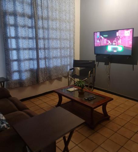 a living room with a couch and a table and a tv at casita de lola in Ciudad Valles