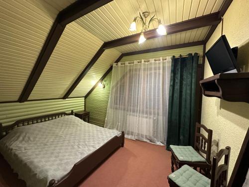 a small bedroom with a bed and a window at SoloMia in Mykulychyn