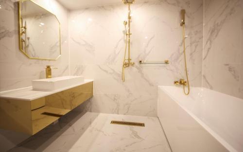 a white bathroom with a sink and a tub at 1954 Hotel in Busan