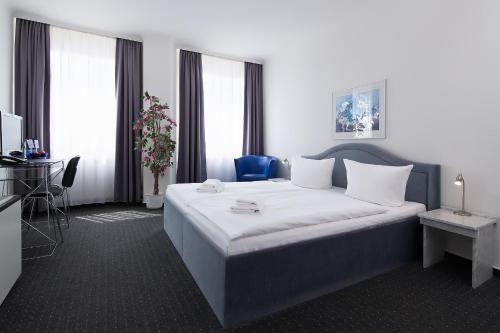 a hotel room with a large bed and a television at Hotel Berliner Bär in Berlin