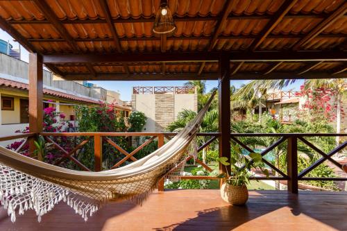 a hammock on a porch with a view at Apartamento Breezes in Jericoacoara
