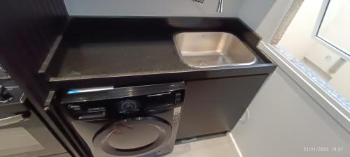 a bathroom with a washing machine and a sink at Apto 5 Estrelas no Centro de Pelotas in Pelotas