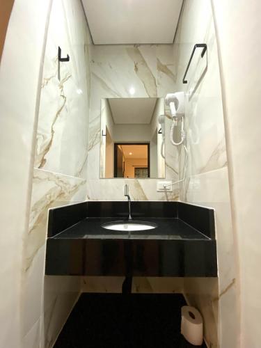 a bathroom with a black sink and a mirror at Villa Licuri Boiçucanga in Boicucanga