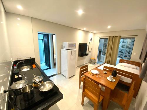 a kitchen and dining room with a stove and a table at Villa Licuri Boiçucanga in Boicucanga