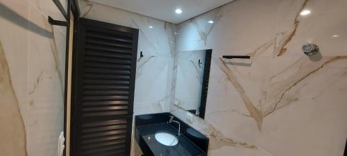 a bathroom with a sink and a mirror at Villa Licuri Boiçucanga in Boicucanga