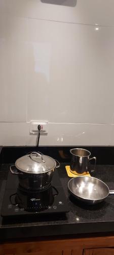 two pots and pans on a stove in a kitchen at Villa Licuri Boiçucanga in Boicucanga