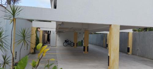 a white building with yellow pillars and a fence at Villa Licuri Boiçucanga in Boicucanga