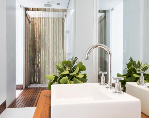 a bathroom with a white sink and a mirror at Pool Villas Tivoli Ecoresort in Praia do Forte