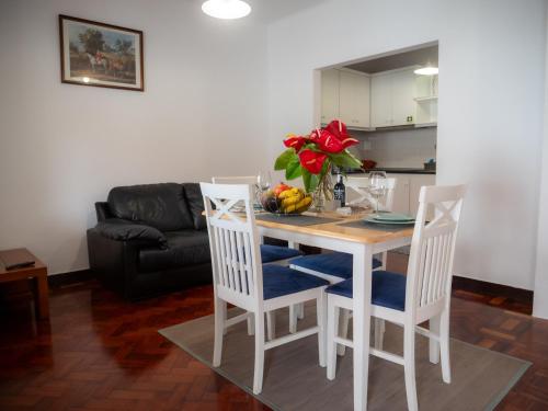 a kitchen and living room with a table and chairs at Maresia's House in Madalena do Mar