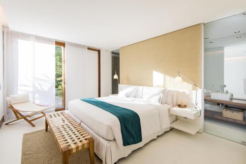 a bedroom with a large white bed and a sink at Pool Villas Tivoli Ecoresort in Praia do Forte