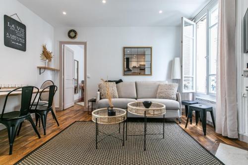 un salon avec un canapé et une table dans l'établissement MBA Splendide Appart - Montreuil 1 - Proche Vincennes, à Montreuil