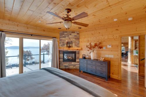 Merrimac的住宿－Lake Wisconsin Lodge with Dock and Pool Near Skiing!，一间卧室配有一张带吊扇和壁炉的床。