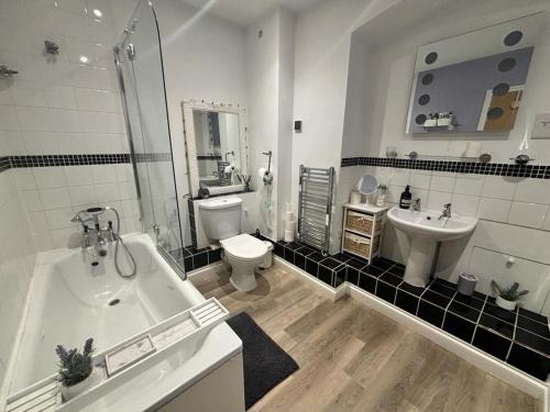 a bathroom with a tub and a toilet and a sink at Ross-on-Wye holiday cottage in Ross on Wye