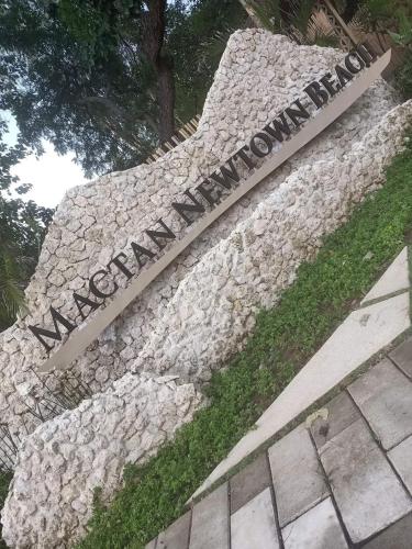 a sign on a stone wall with the name of a monument at Mactan Newtown Beach Condo in Mactan