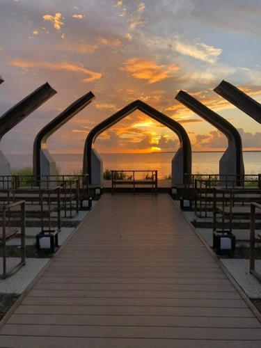 a boardwalk leading to the beach at sunset at Mactan Newtown Beach Condo in Mactan