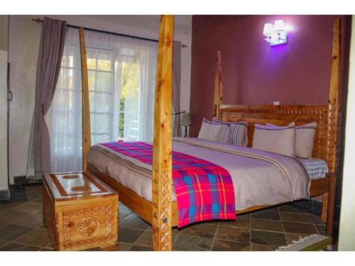a bedroom with a large bed with a four poster bed sidx sidx sidx at Tobriana in Nairobi