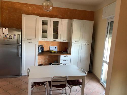 a kitchen with a white table and a refrigerator at Casa Zanardi 2.0 in Bologna