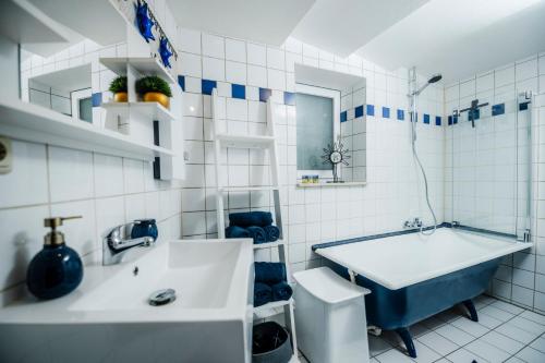 Rimpar的住宿－Ferienhaus Zum Goldschmied，白色的浴室设有浴缸和水槽。