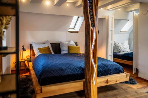 a bedroom with a bed with a blue comforter at Ferienhaus Zum Goldschmied in Rimpar