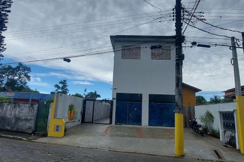 un edificio con porte blu sul lato di una strada di Villa Licuri Boiçucanga a Boicucanga