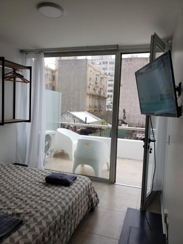 a bedroom with a bed and a flat screen tv at Venezuela Apartament Premiun in Buenos Aires