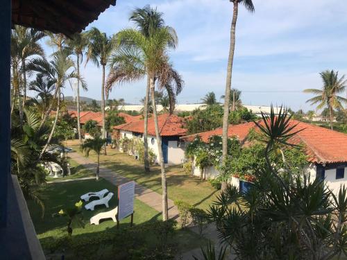 una vista dal balcone di un resort con palme di Flat Bangalô a Cabo Frio