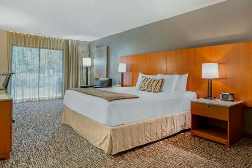Habitación de hotel con cama grande y ventana grande. en BW Premier Collection, Mt Hood Oregon Resort, en Welches