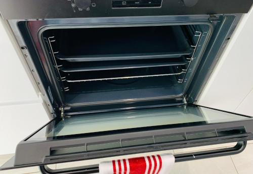 an open oven with a red and white object in it at Beautiful, Luxurious 3 Bed house, Perfect for Contractors , Family & Friends in Dartford