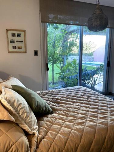 a bed in a bedroom with a large window at Casa Feliz in San Fernando del Valle de Catamarca