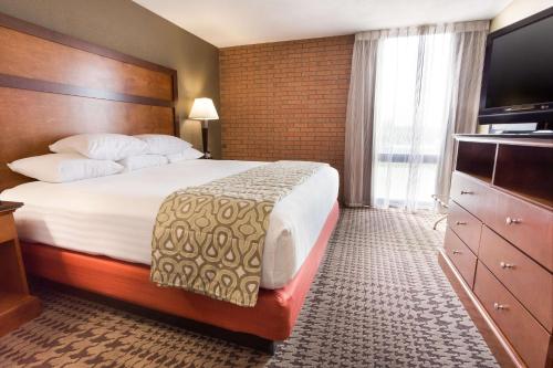 a hotel room with a bed and a flat screen tv at Drury Inn & Suites Jackson MO in Jackson