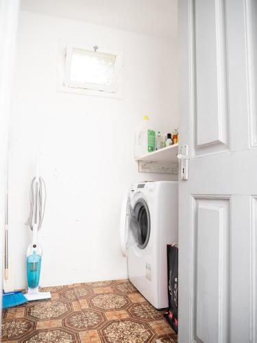 a white laundry room with a washing machine in it at Isabela House in Ponta do Sol