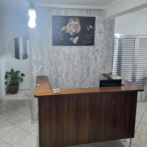 a desk with a picture of a lion on a wall at Hostel ANPRADO in Guarulhos