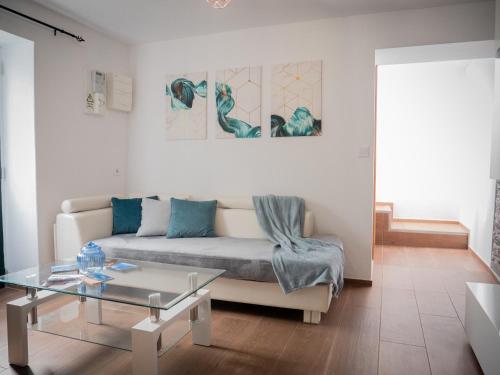 a living room with a couch and a glass table at Isabela House in Ponta do Sol