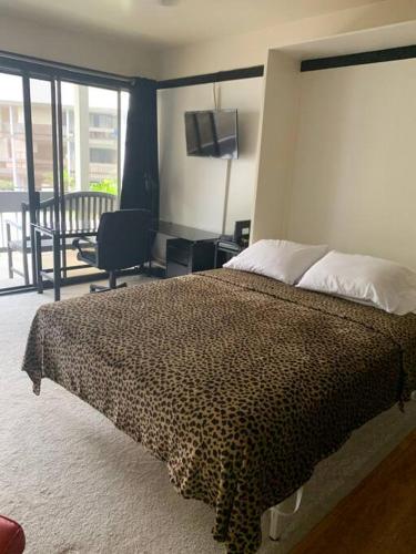 a bedroom with a bed with a leopard print blanket at Lucy's Place -STUDIO Apt with air-conditioning, Murphy bed in Hilo
