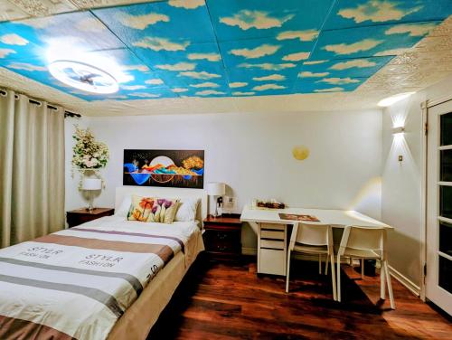 a bedroom with a bed and a desk and a ceiling with clouds at Cozy and quiet house with private swimming pool in Toronto