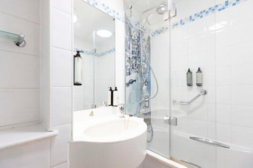 a white bathroom with a shower and a sink at Holiday Inn - Glasgow Airport by IHG in Paisley