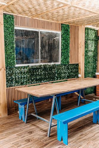 a green wall with a wooden table and benches at 2 Cabañas para 5 Personas Oasis Pica-Matilla in Pica