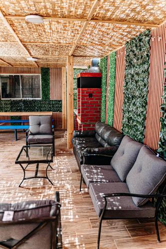 a living room with couches and chairs and a wall with plants at 2 Cabañas para 5 Personas Oasis Pica-Matilla in Pica