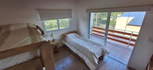 een kleine slaapkamer met 2 stapelbedden en een raam bij Terrazas de Nahuascat in Santa Rosa de Calamuchita