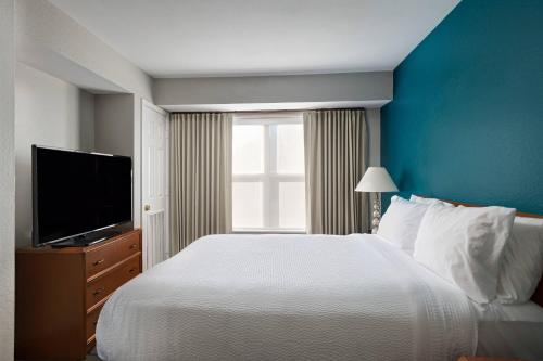 a bedroom with a large bed and a television at Residence Inn Shreveport Airport in Shreveport