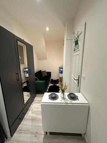 a room with a white table and a living room at Superbe appartement hyper centre-ville de Melun in Melun