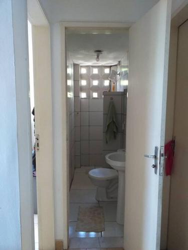 La salle de bains blanche est pourvue de toilettes et d'un lavabo. dans l'établissement apartamento encantador bem ventilado, excelente localização na av Dom Luís., à Fortaleza