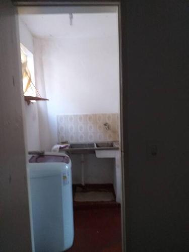 een kleine badkamer met een wastafel en een wasmachine bij apartamento encantador bem ventilado, excelente localização na av Dom Luís. in Fortaleza