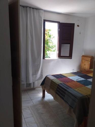 een slaapkamer met een bed en een raam bij apartamento encantador bem ventilado, excelente localização na av Dom Luís. in Fortaleza