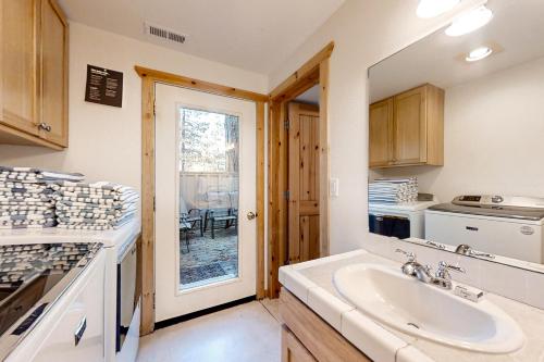 eine Küche mit einem Waschbecken und einer Theke mit einem Fenster in der Unterkunft 4 Mink Lane in Sunriver
