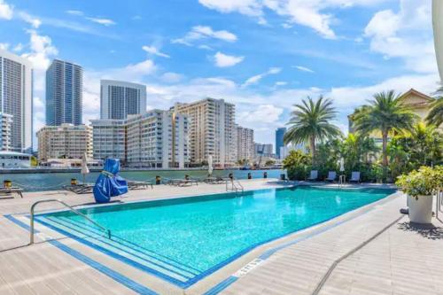 a swimming pool with a city skyline in the background at Ocean Views - Pool & Gym - Pet Friendly - Close to Beach in Hallandale Beach