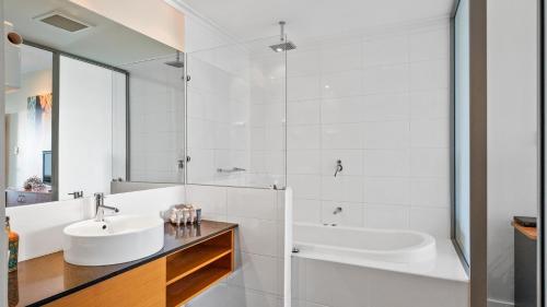 a white bathroom with a sink and a tub at Sea Side 112 in Mandurah