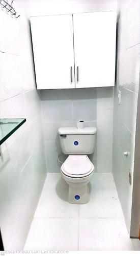 een witte badkamer met een toilet en een kast bij Tu refugio del descanso in Medellín