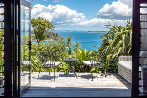 d'un balcon avec des chaises et une vue sur l'océan. dans l'établissement The Moorings Studio Apartments, à Oneroa