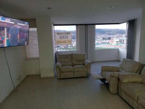 sala de estar con 2 sofás y TV de pantalla plana en Lujoso Hospedaje en las Alturas, en Tunja